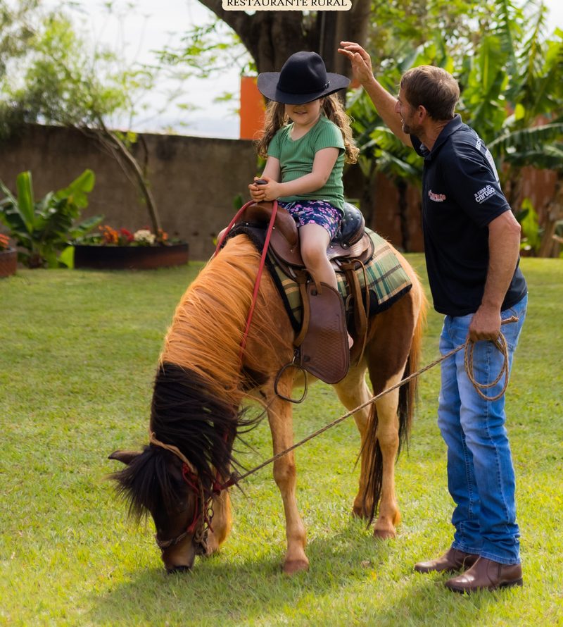 Criança passeando de pônei