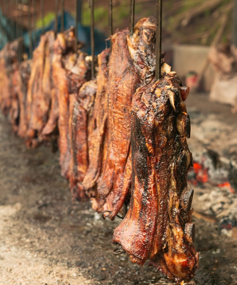 Costelas assando espetadas no fogo de chão
