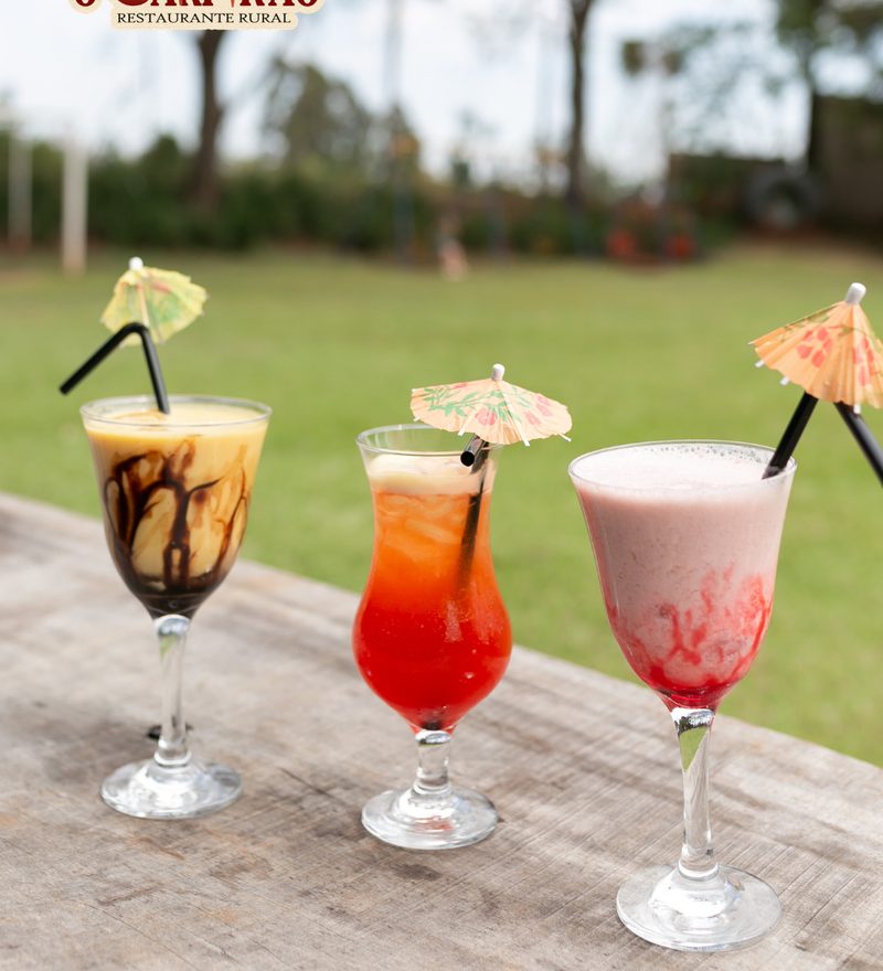 Três drinks coloridos no jardim
